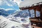 Winterurlaub in Alpbach Aussicht auf das wunderschön verschneite Alpbachtal, alles bedeckt von Schnee, im Vordergrund ein Haus im einzigartigen Alpbacher Baustil