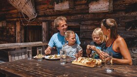 Eine Familie isst genüsslich eine Brettljause auf der Farmkehralm in Inneralpbach | © Alpbachtal Tourismus | Mathäus Gartner 